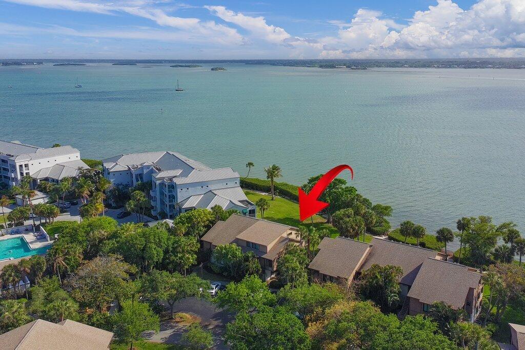An aerial view shows waterfront townhomes surrounded by trees and a grassy lawn — 218 NE Edgewater Drive # 218, Hutchinson Island FL 34996, HUTCHINSON ISLAND, FL