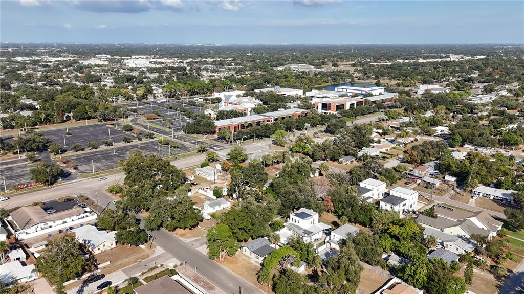 An aerial view shows a residential neighborhood adjacent to a large parking lot and buildings — 6948 DARTMOUTH AVENUE N, ST PETERSBURG, FL