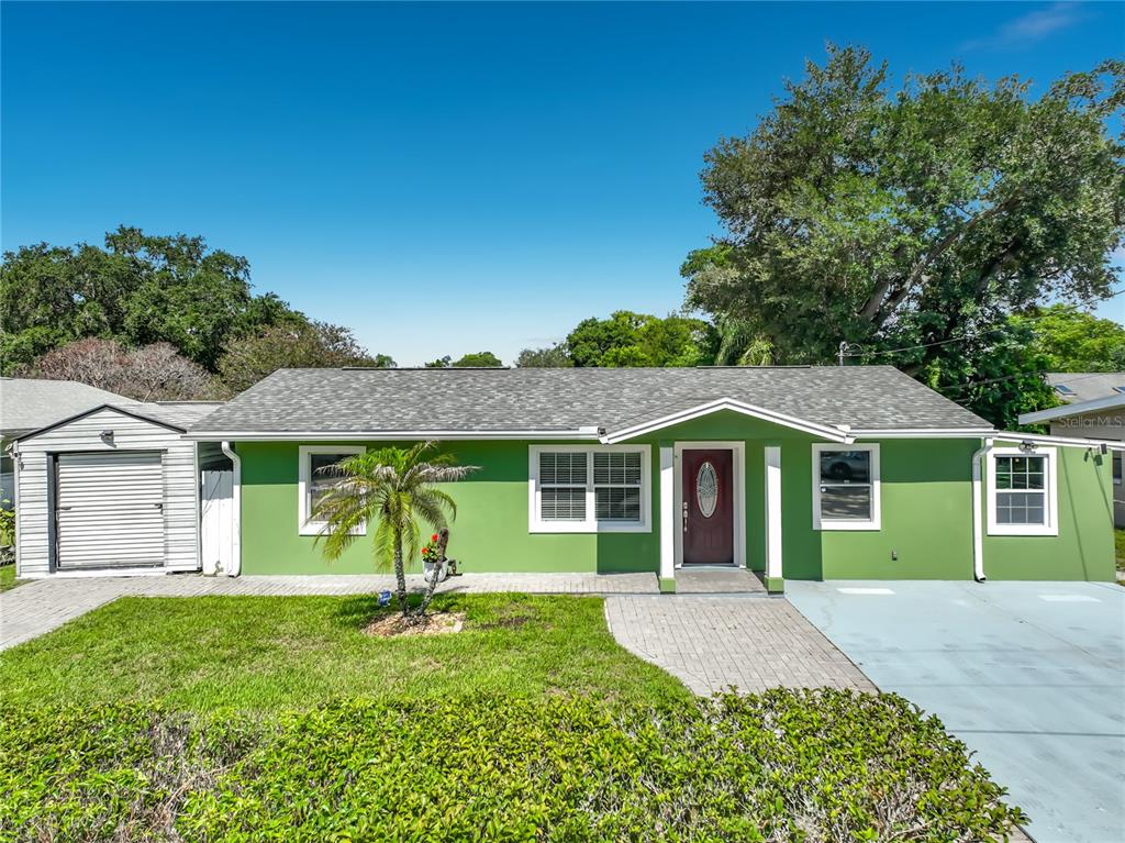 A single-story green house with a gray shingled roof and a paved front walkway — 3312 S FOREST STREET, ORLANDO, FL