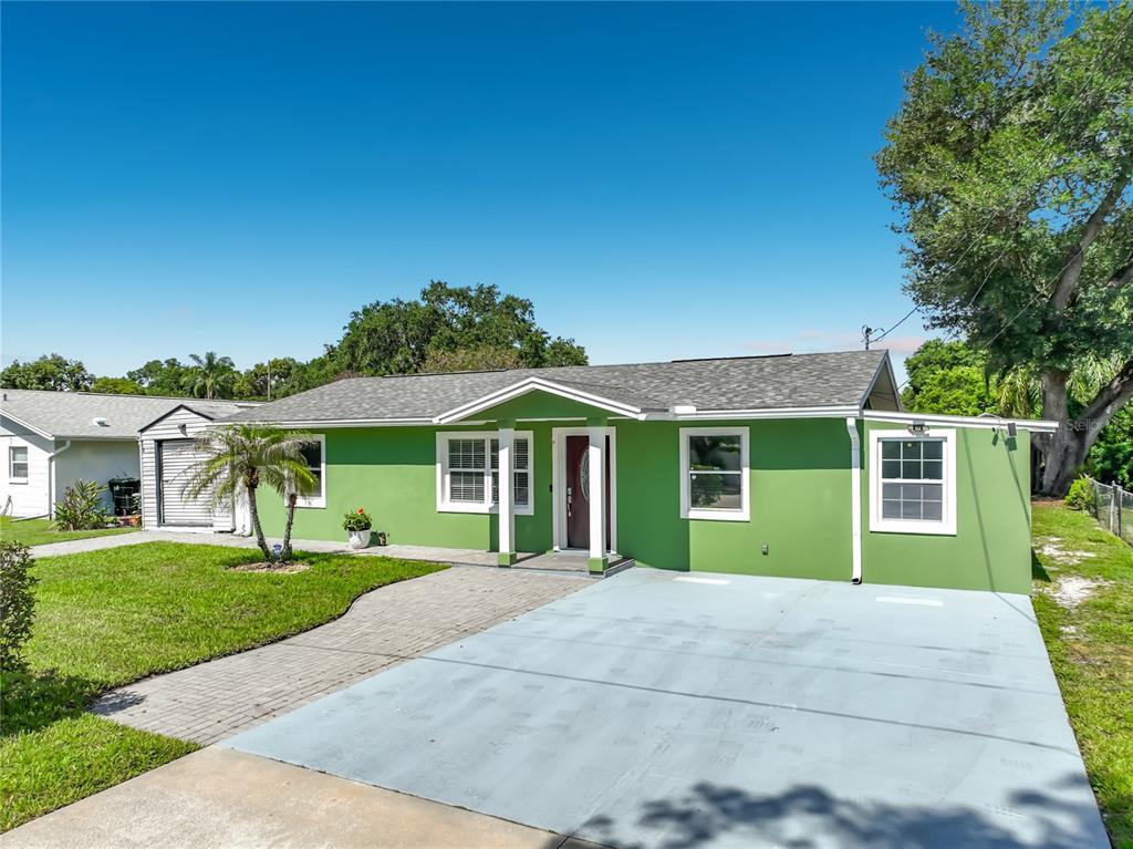 A lime green single-story house with a gray shingled roof and a paved driveway — 3312 S FOREST STREET, ORLANDO, FL