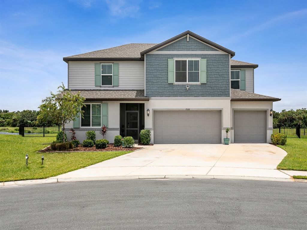 An aerial view of a two-story house with a three-car garage and a backyard pond — 7008 NORRIS LANDING PLACE, PARRISH, FL
