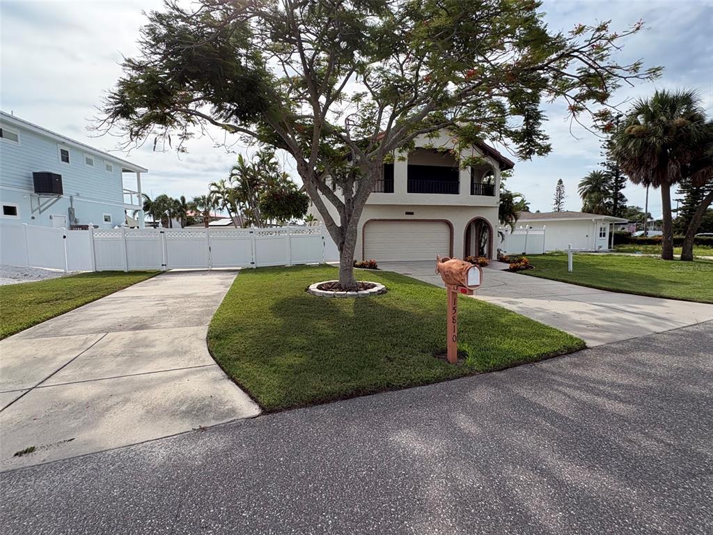 A two-story house with a large tree in the front yard and a decorative mailbox — 15810 REDINGTON DRIVE, REDINGTON BEACH, FL