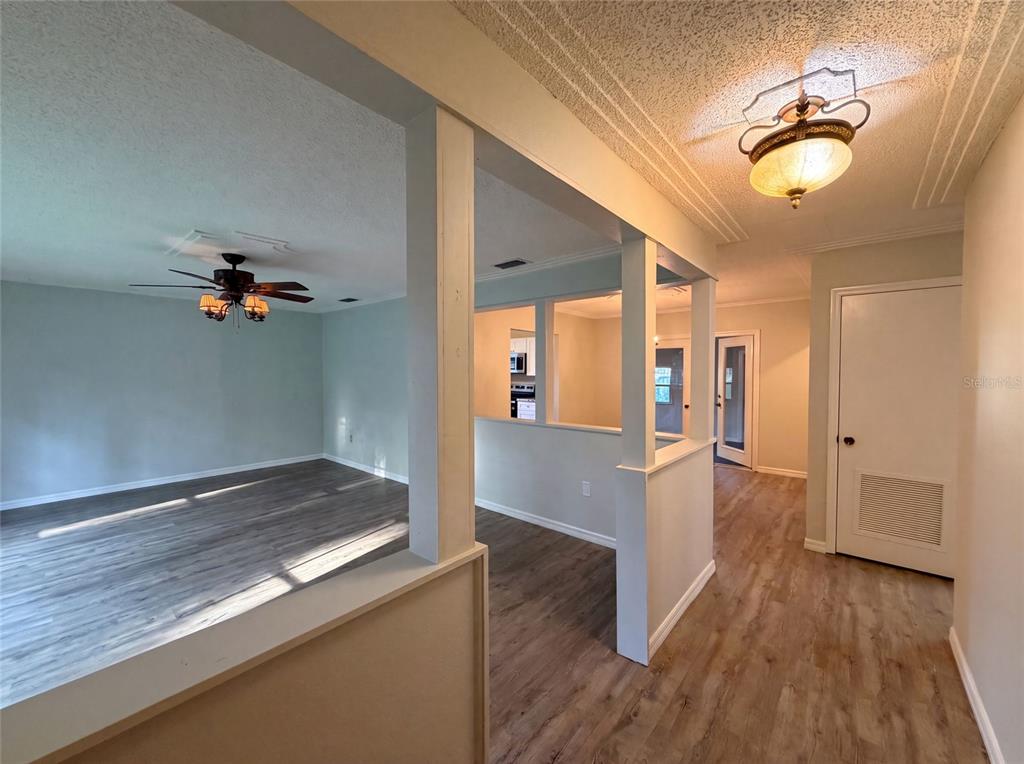 A view of a living area with wood-look flooring, a ceiling fan, and half-walls — 5750 NW 55TH AVENUE, OCALA, FL