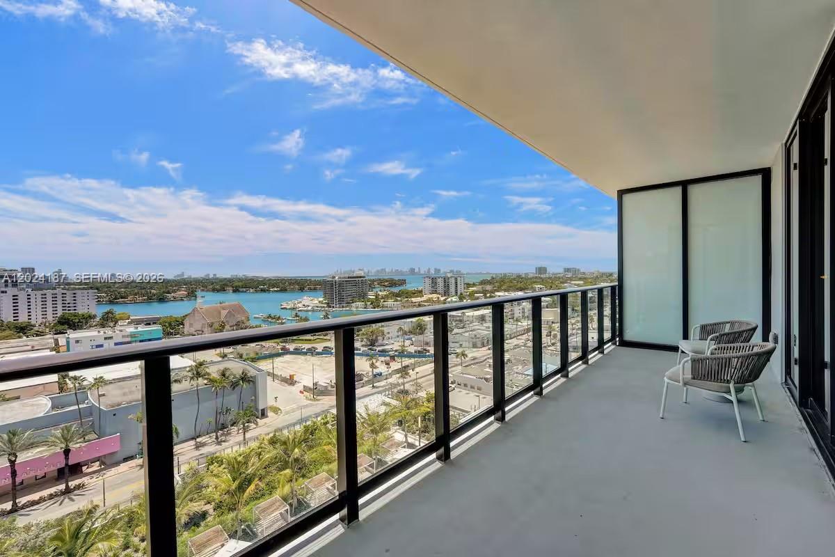 A high-rise balcony features a black metal railing, two chairs, and a panoramic water view — 580 72 ST # 1804, Miami Beach 34553, MIAMI BEACH, FL