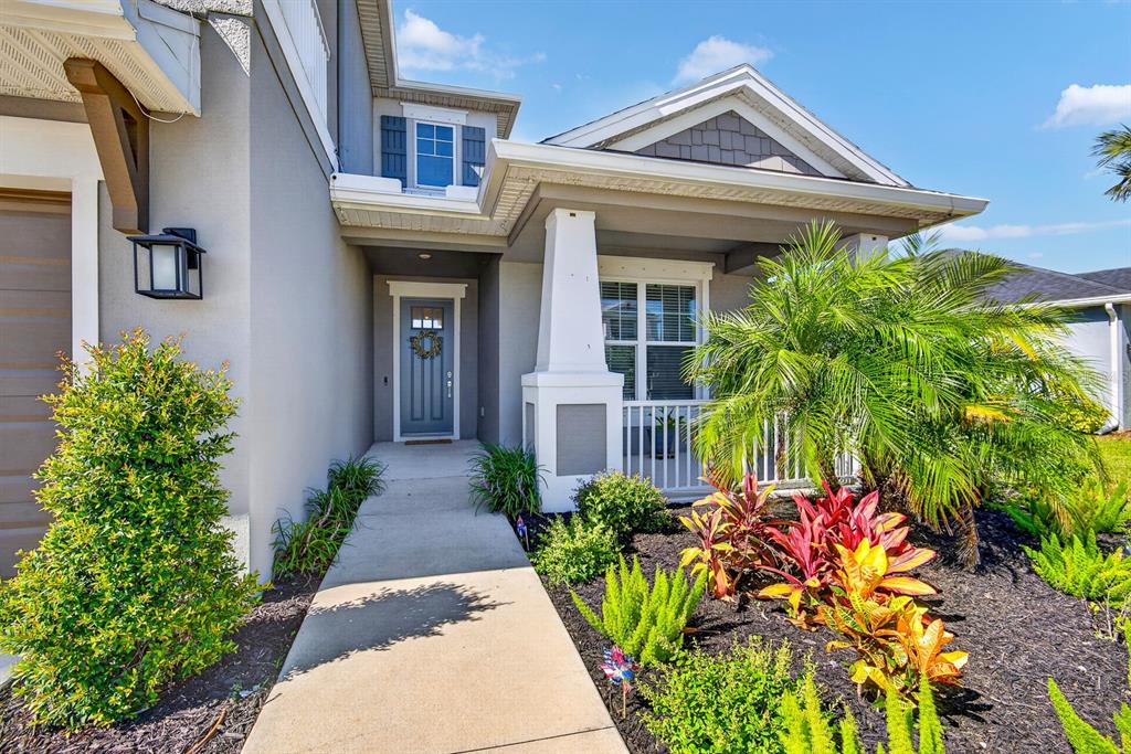 A concrete walkway leads to the front entrance of a house with a covered porch — 5825 FIELDMOOR COURT, PALMETTO, FL