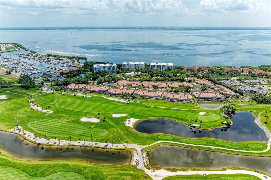 An aerial view shows a golf course, residential buildings, and a marina along a bay — 2350 HARBOUR OAKS DRIVE, LONGBOAT KEY, FL