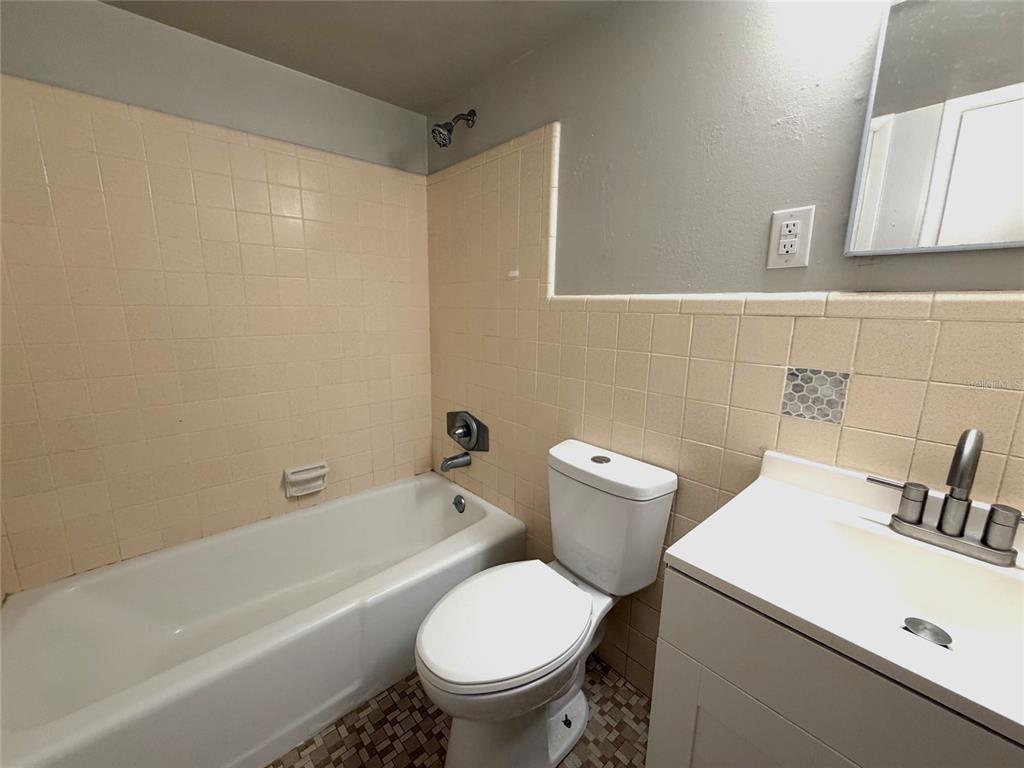 A kitchen features stainless steel appliances, white cabinetry, and light-colored countertops — 501 NW 15TH AVENUE UNIT 9, GAINESVILLE, FL