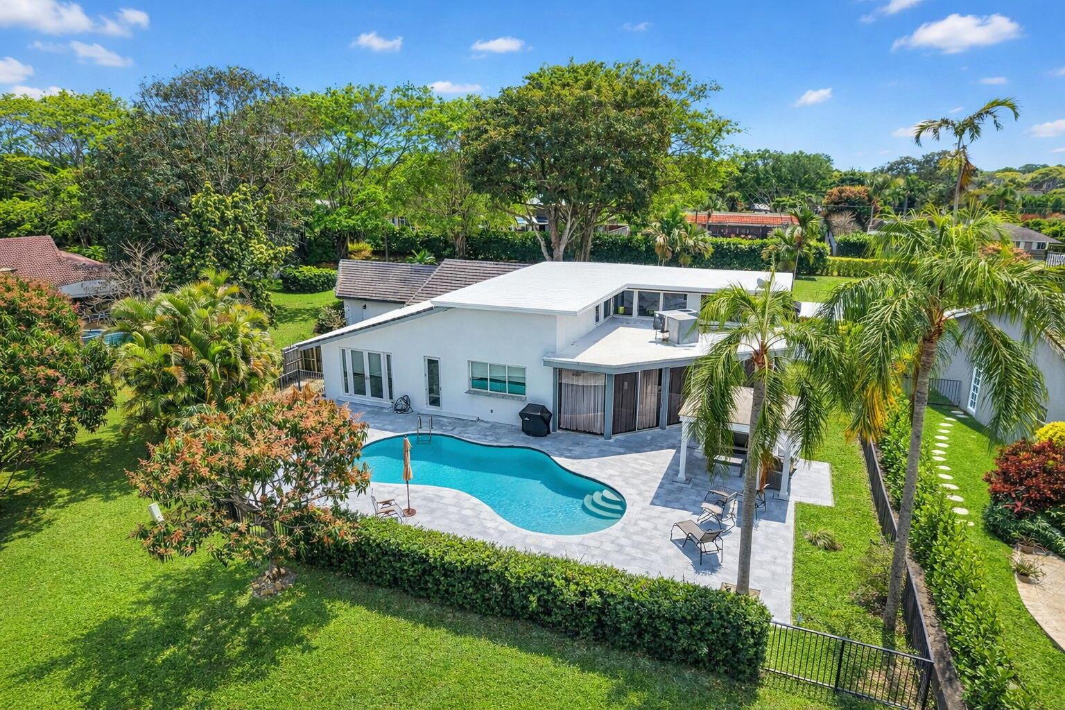 An aerial view of a white house with a swimming pool and a large backyard — 4869 Pineview Circle, Delray Beach FL 33445, DELRAY BEACH, FL
