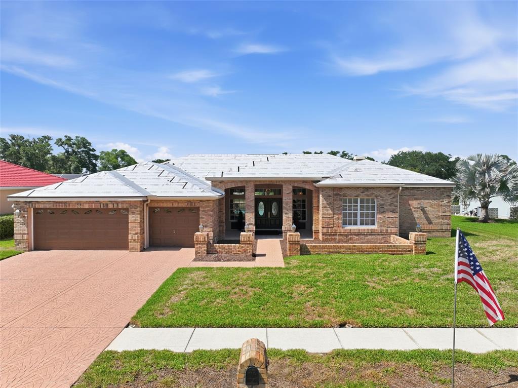 A single-story brick house with a garage and an unfinished roof under a blue sky — 3166 STERLING STREET, TARPON SPRINGS, FL