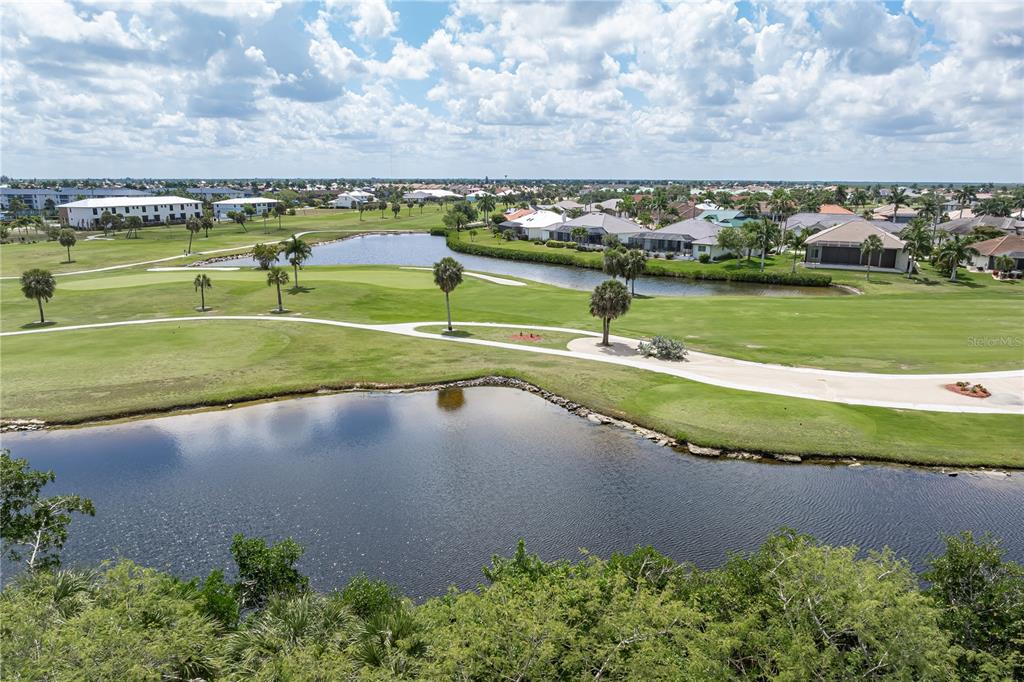 An aerial view of a golf course with ponds, palm trees, and surrounding residential houses — 2053 PADRE ISLAND DRIVE, PUNTA GORDA, FL