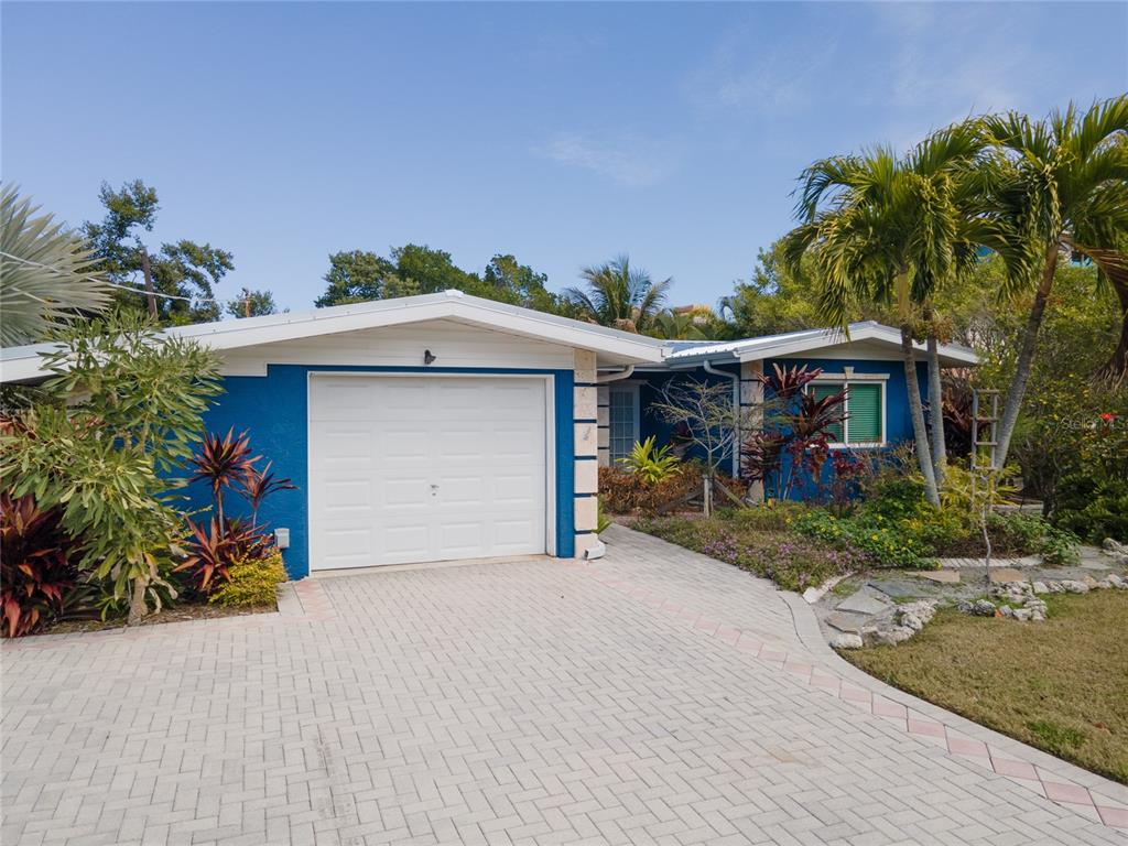 A blue house with a white garage door and a paved driveway under a clear sky — 504 58TH STREET, HOLMES BEACH, FL