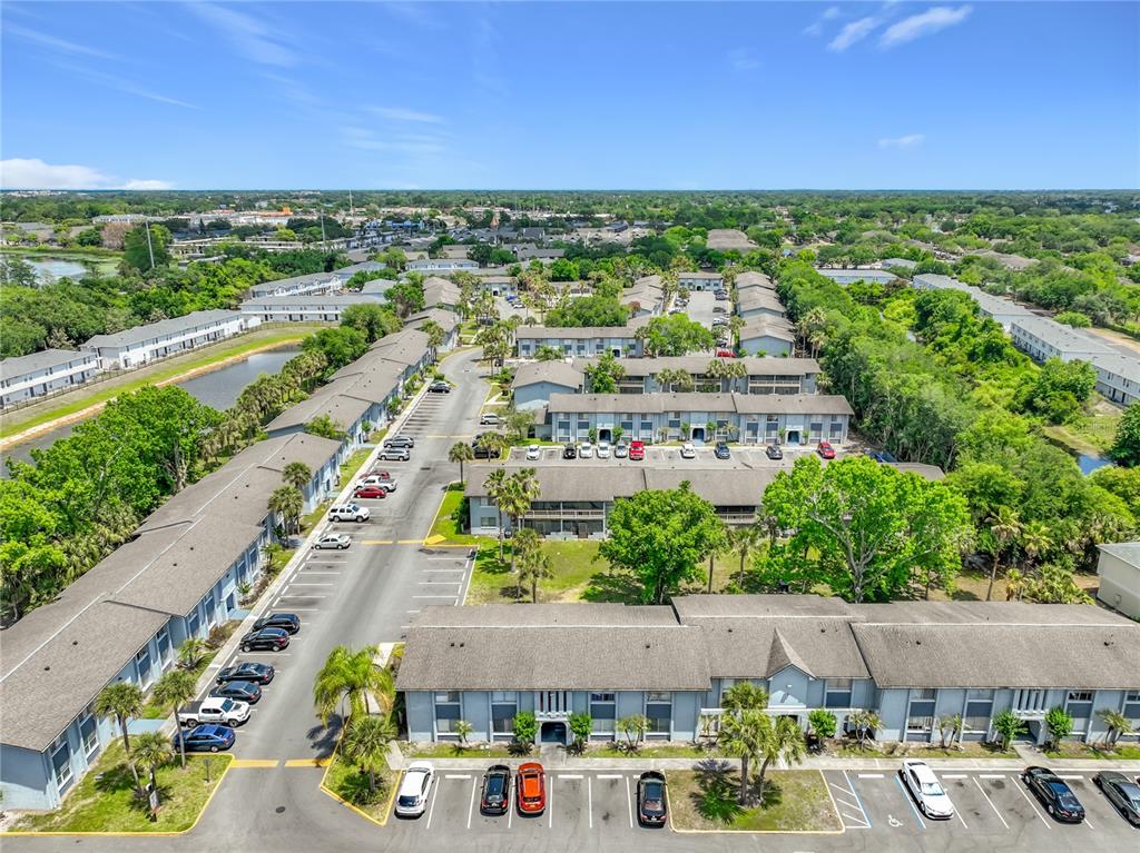 An aerial view shows multiple apartment buildings surrounded by trees, parking lots, and a pond — 4805 S TEXAS AVENUE UNIT 4805A, ORLANDO, FL