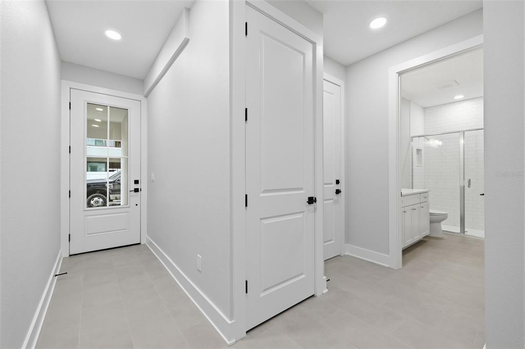 A bright entryway with light tile flooring, white walls, two interior doors, and a bathroom — 4208 W CARMEN STREET UNIT C, TAMPA, FL