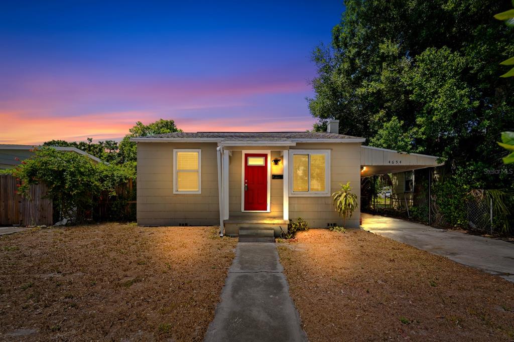 A single-story house with a red front door and an attached carport at sunset — 4654 13TH AVENUE S, ST PETERSBURG, FL