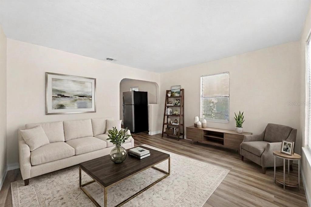 A living room features a beige sofa, a coffee table, and wood-look flooring — 4654 13TH AVENUE S, ST PETERSBURG, FL