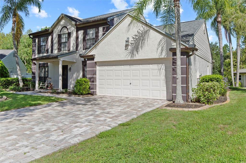 A two-story house with a paved driveway, a two-car garage, and palm trees — 16126 COUNTRY CROSSING DRIVE, TAMPA, FL