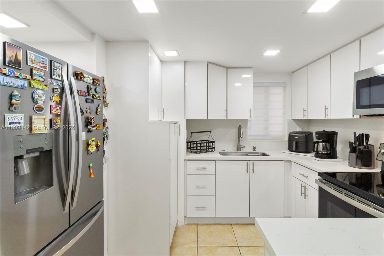 A modern kitchen features white cabinets, stainless steel appliances, and a stainless steel refrigerator — 840 NW 87th Ave # 405, Miami FL 33172, MIAMI, FL