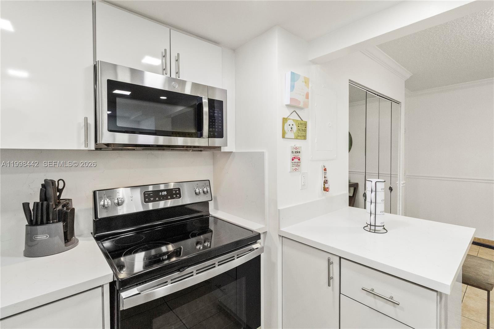 A kitchen features white cabinets, stainless steel appliances, and white countertops — 840 NW 87th Ave # 405, Miami FL 33172, MIAMI, FL