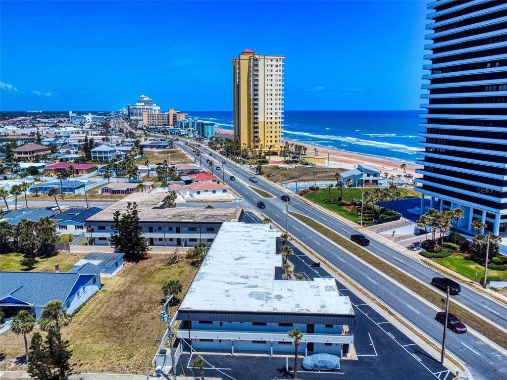 An aerial view shows a low-rise building next to a road and high-rise beach hotels — 2101 N ATLANTIC AVENUE UNIT 10, DAYTONA BEACH, FL