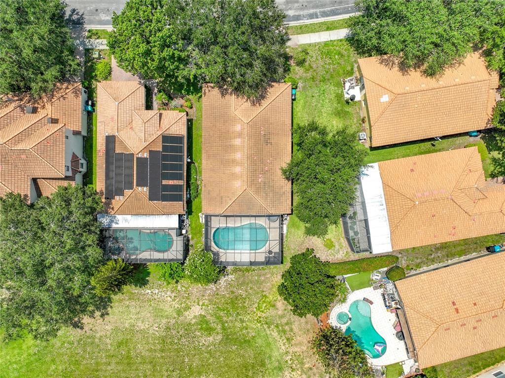 An aerial view shows several suburban houses with tiled roofs, swimming pools, and backyard landscaping — 5915 BUFORD STREET, ORLANDO, FL