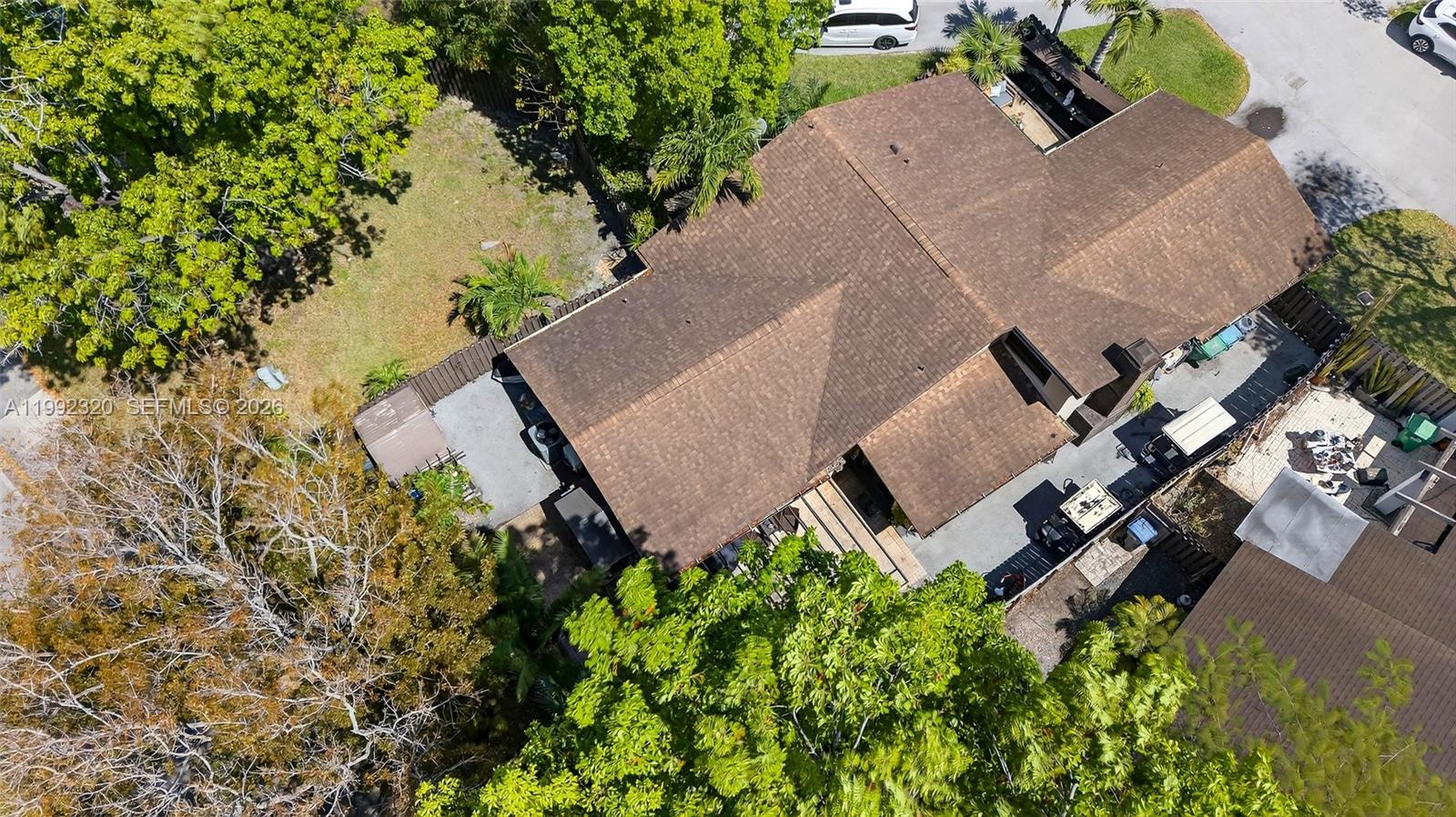 An aerial view shows a residential house with a brown shingled roof and surrounding trees — 10861 SW 132nd Cir Ct, Miami FL 33186, MIAMI, FL