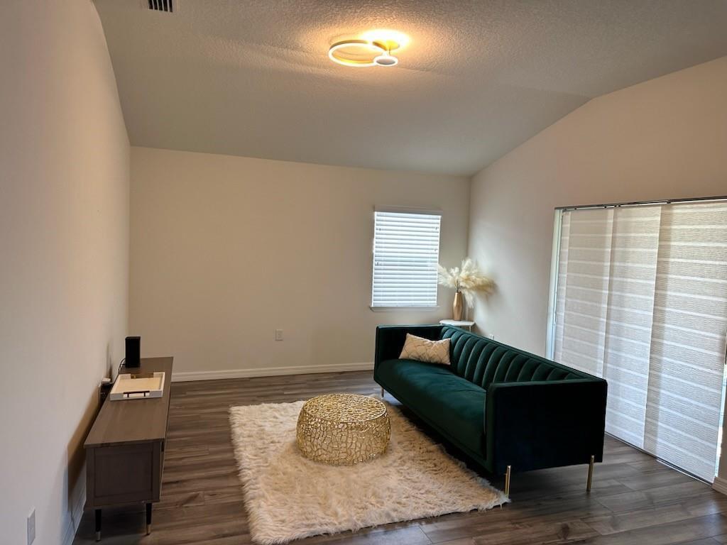 A living room features a green velvet sofa, gold coffee table, and wood-look flooring — 1099 NE Dania Circle, Palm Bay FL 32905, PALM BAY, FL