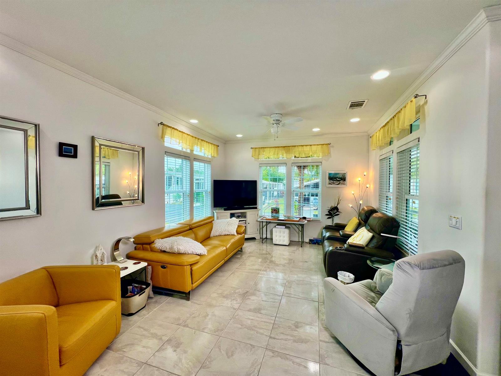 A living room features tile flooring, yellow and dark leather seating, and multiple windows — 413 Hibiscus Drive, Deerfield Beach FL 33442, DEERFIELD BEACH, FL