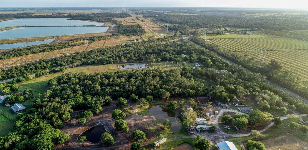 An aerial view shows a rural property with multiple ponds, wooded areas, and agricultural fields — 11470 Carlton Road, Port St. Lucie FL 34987, PORT ST. LUCIE, FL