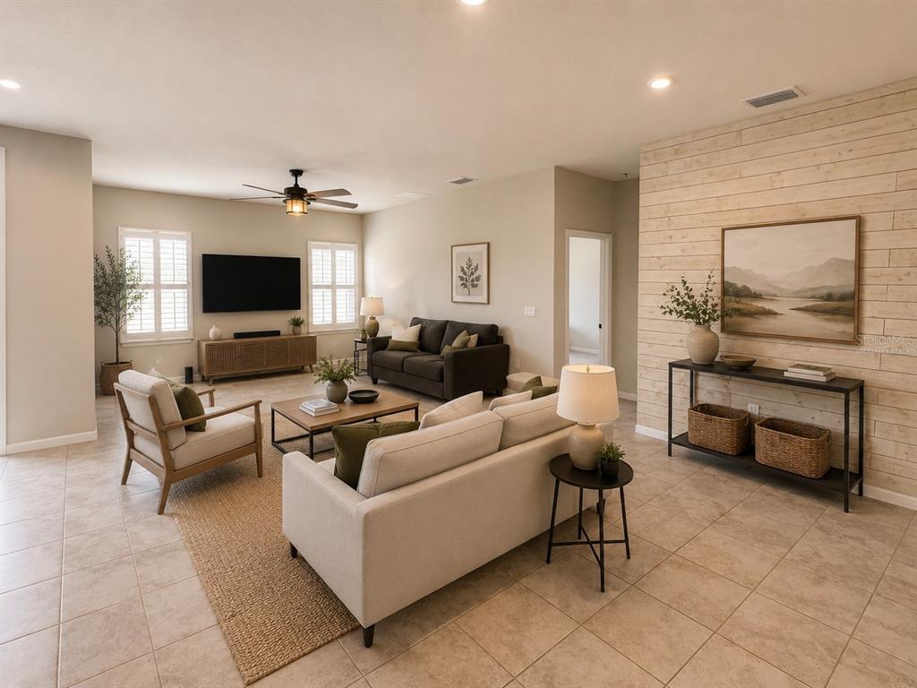 A living room features tile floors, a shiplap accent wall, and neutral-toned furniture — 18217 FALLING PINE NEEDLE LANE, LAND O LAKES, FL