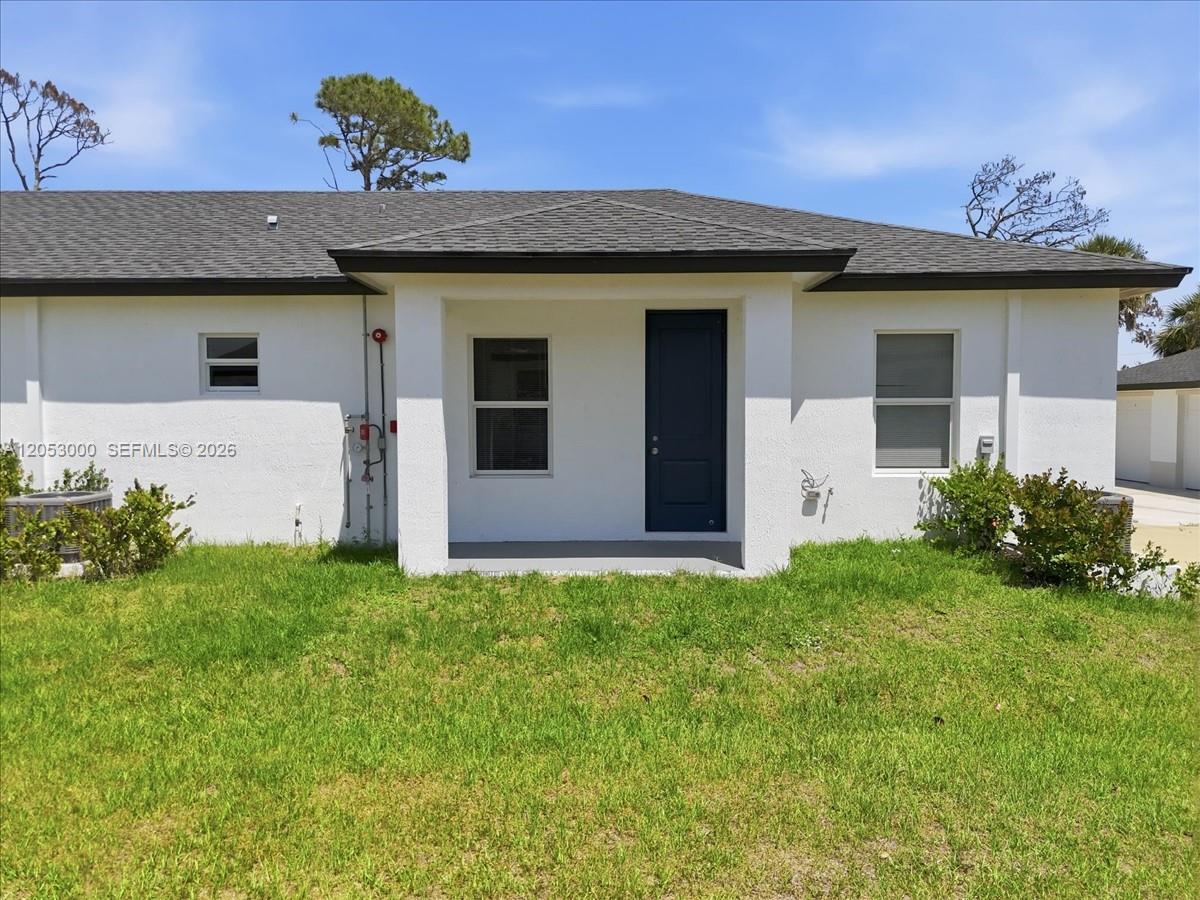A white house exterior features a dark front door, a covered porch, and a lawn — 195 Rotonda # C, Port Charlotte FL 33947, PORT CHARLOTTE, FL