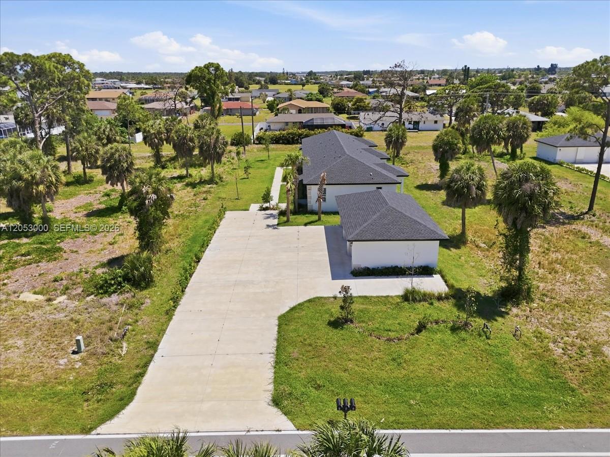 An aerial view shows a white house with a dark roof and a long concrete driveway — 195 Rotonda # C, Port Charlotte FL 33947, PORT CHARLOTTE, FL