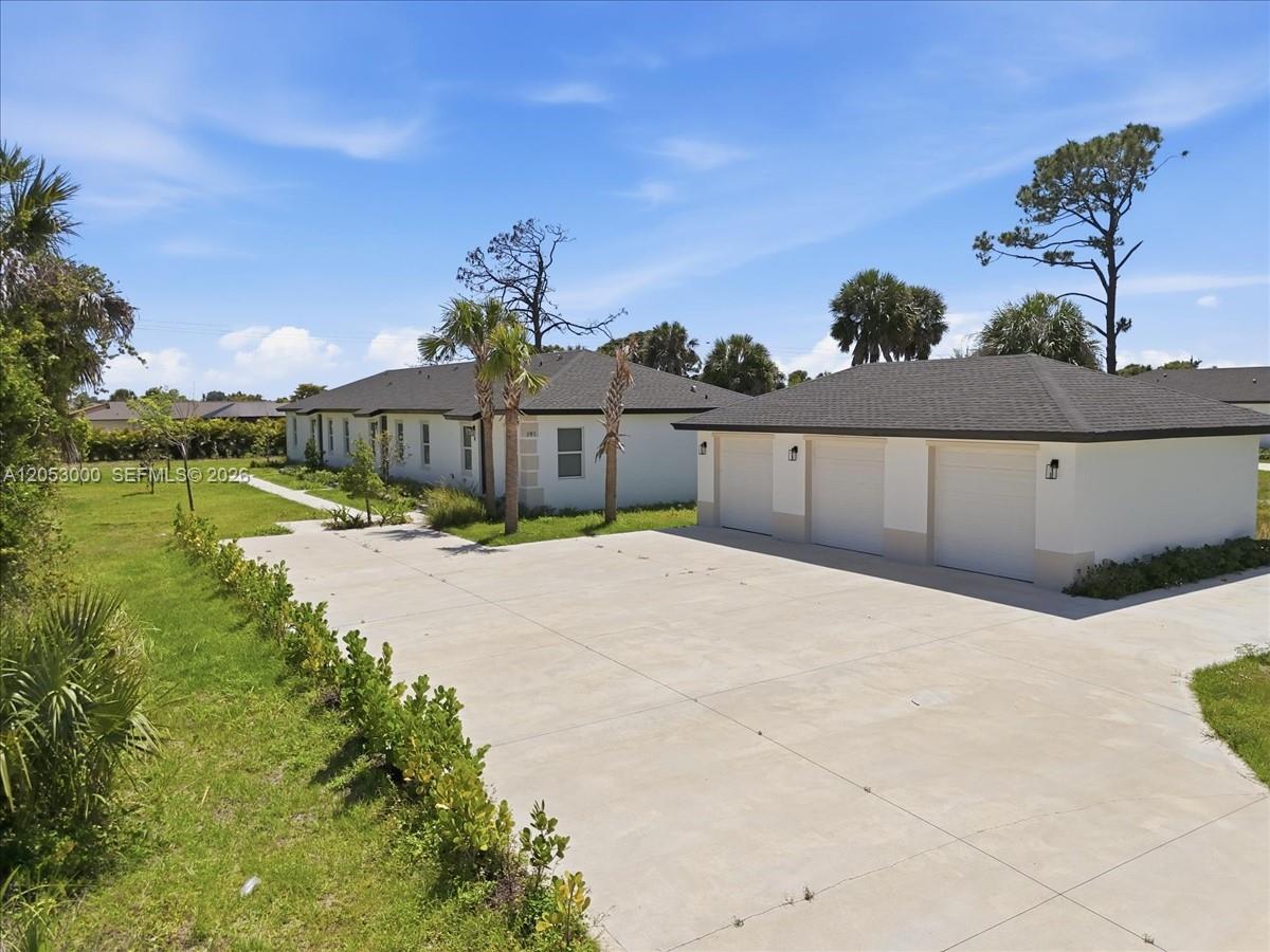 An exterior view of a single-story house with a three-car garage and concrete driveway — 195 Rotonda # C, Port Charlotte FL 33947, PORT CHARLOTTE, FL