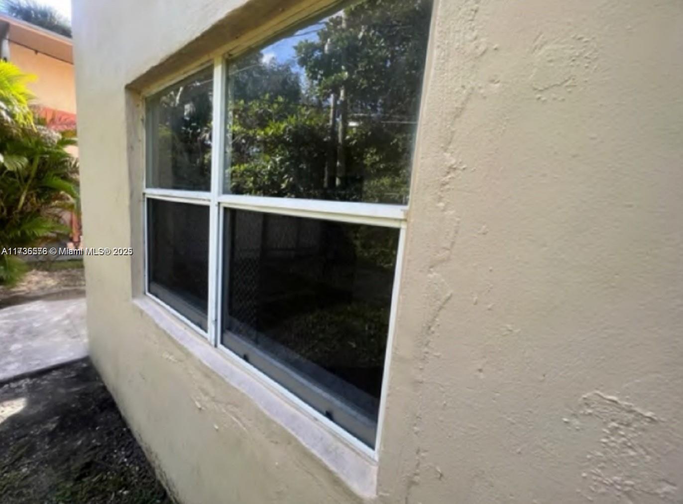 An exterior view of a tan stucco wall featuring a white-framed window — 624 SW 16th Ave # C, Fort Lauderdale FL 33312, FORT LAUDERDALE, FL