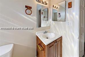 A bathroom features a wooden vanity with a white sink, a mirror, and a towel ring — 624 SW 16th Ave # C, Fort Lauderdale FL 33312, FORT LAUDERDALE, FL