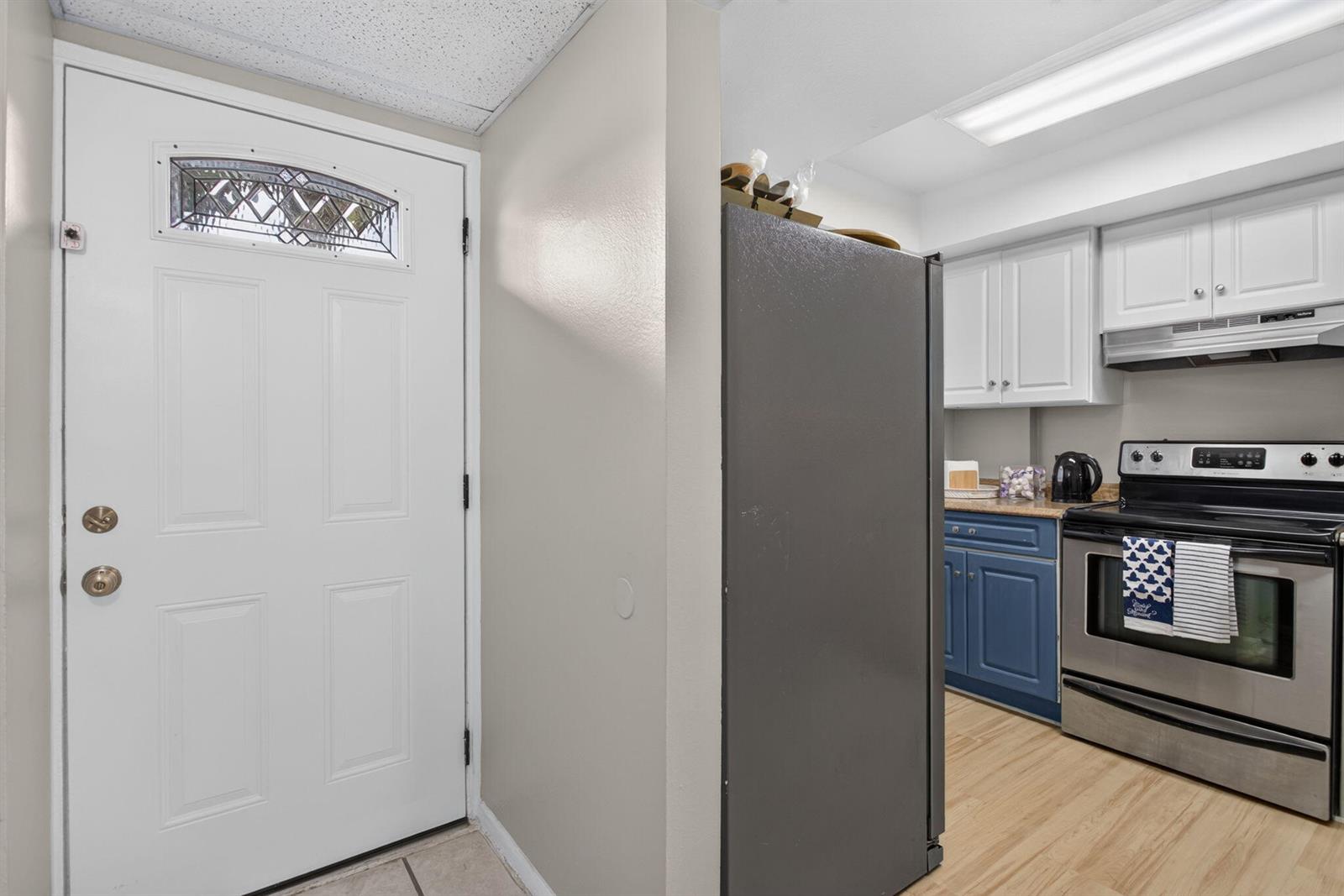 A kitchen with blue lower cabinets, white upper cabinets, and a stainless steel stove — 118 Royal Pk Drive # 1f, Oakland Park FL 33309, OAKLAND PARK, FL