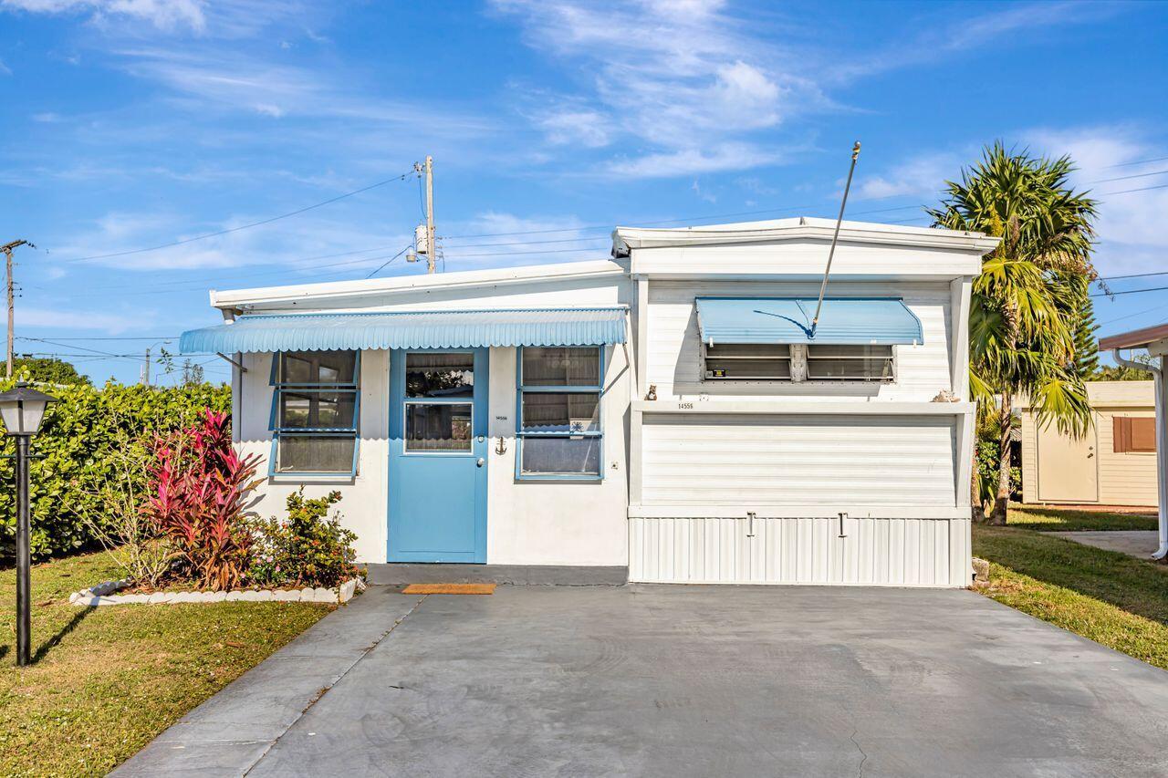 A white mobile home with a blue door, blue awnings, and a concrete driveway — 14556 Glenview Drive, Delray Beach FL 33445, DELRAY BEACH, FL