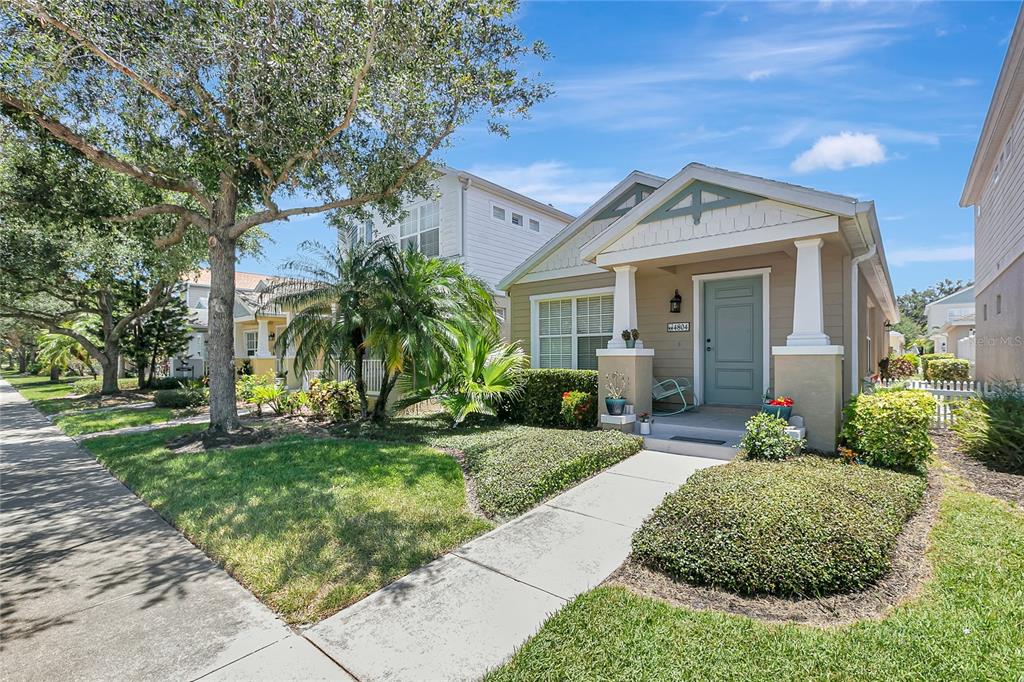 A tan single-story house with a blue front door and a sidewalk leading to it — 4804 FOREST CREEK TRAIL, PARRISH, FL