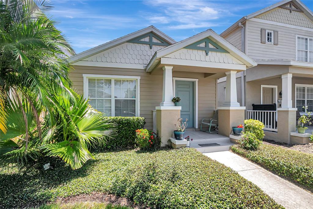 A tan single-story house with a covered front porch and a palm tree in front — 4804 FOREST CREEK TRAIL, PARRISH, FL