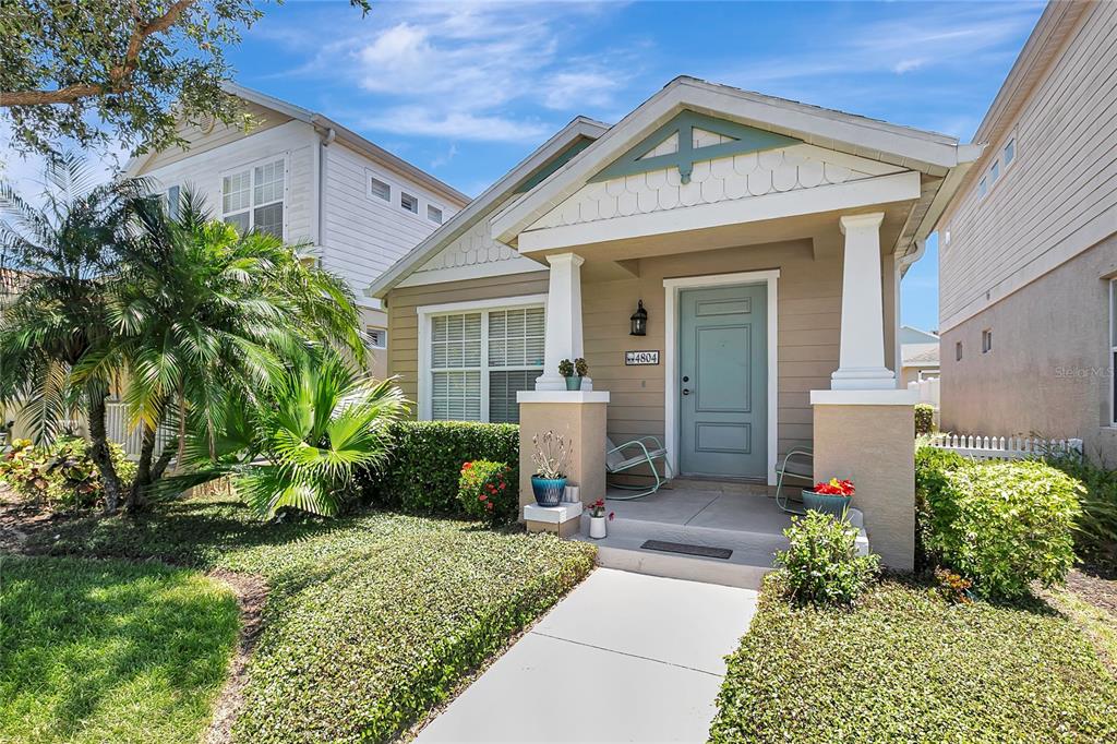 A tan single-story house with a front porch, columns, and a light blue door — 4804 FOREST CREEK TRAIL, PARRISH, FL