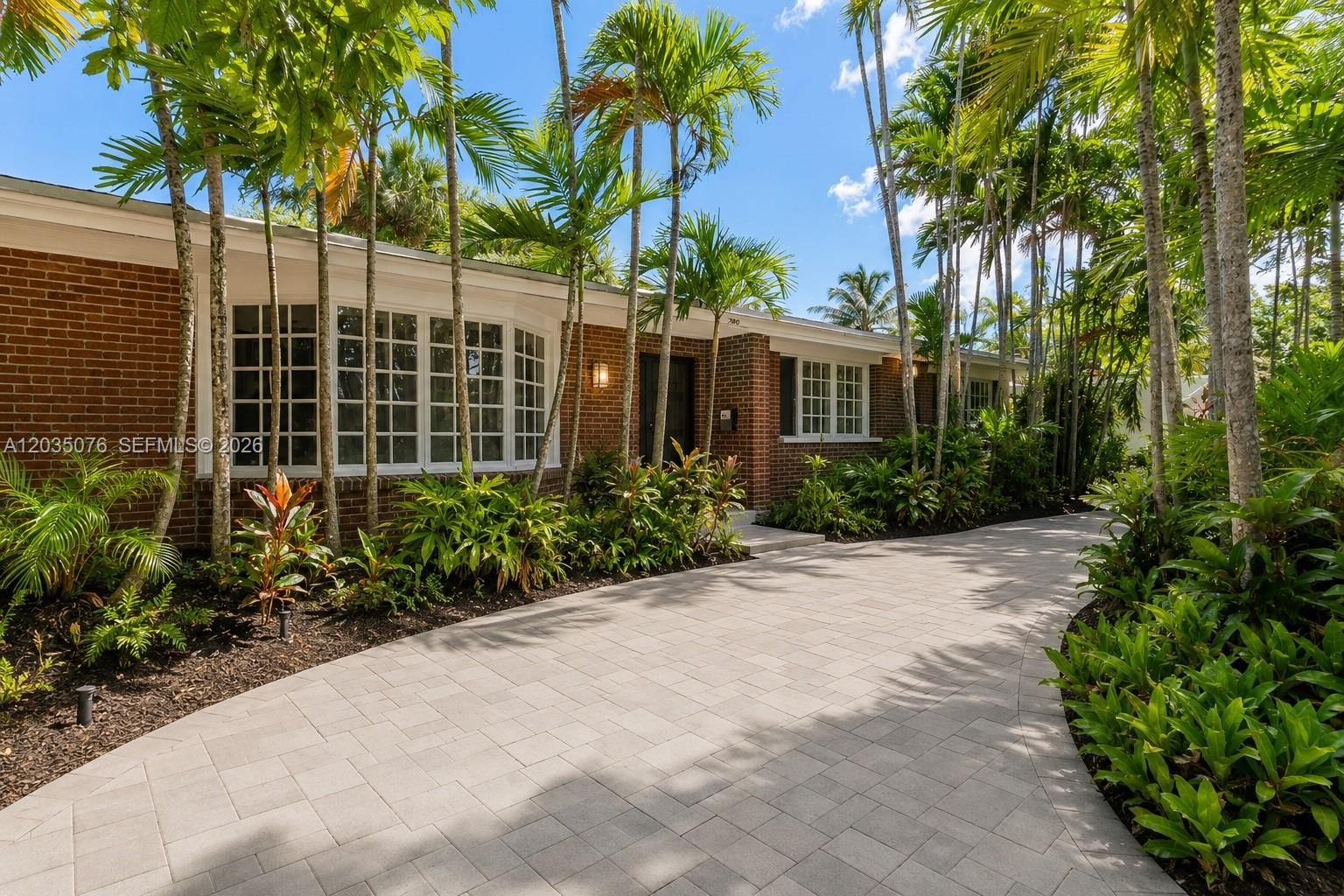 A brick house with a paved driveway and palm trees in the front yard — 785 NE 155th St, Miami FL 33162, MIAMI, FL