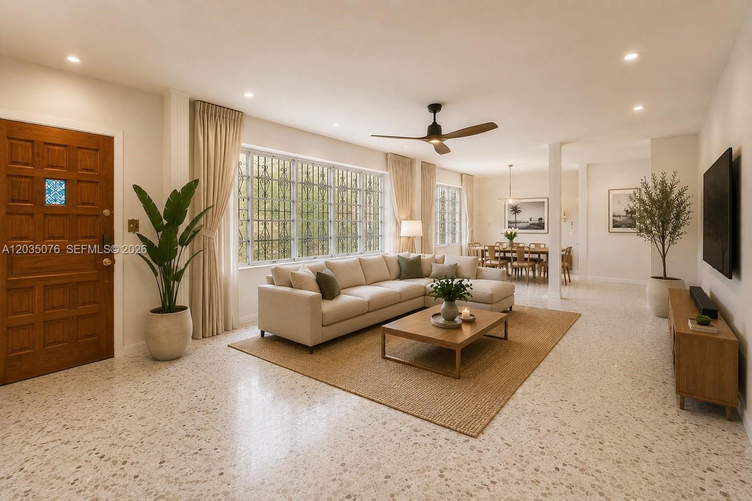 A living room features a beige sectional sofa, a wooden coffee table, and terrazzo flooring — 785 NE 155th St, Miami FL 33162, MIAMI, FL