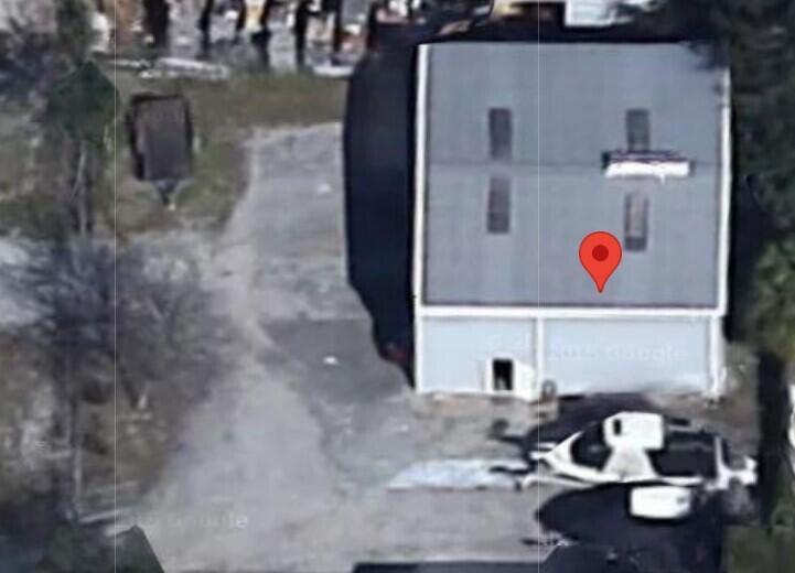 An aerial view shows a rectangular building with a gray roof and a parking area — 816 SW 11th Dr Drive SW, Vero Beach FL 32962, VERO BEACH, FL