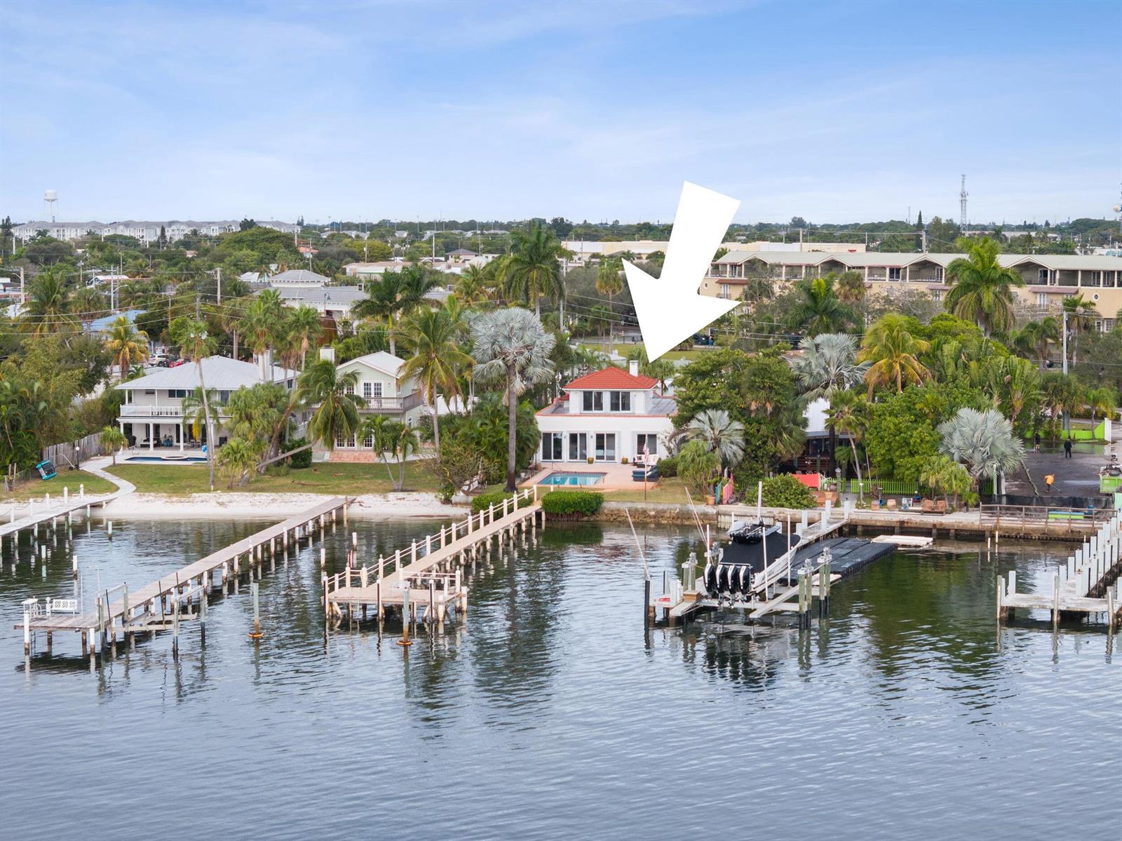 An aerial view shows a waterfront house with a pool, dock, and boat lift — 114 S Lake Drive, Lantana FL 33462, LANTANA, FL