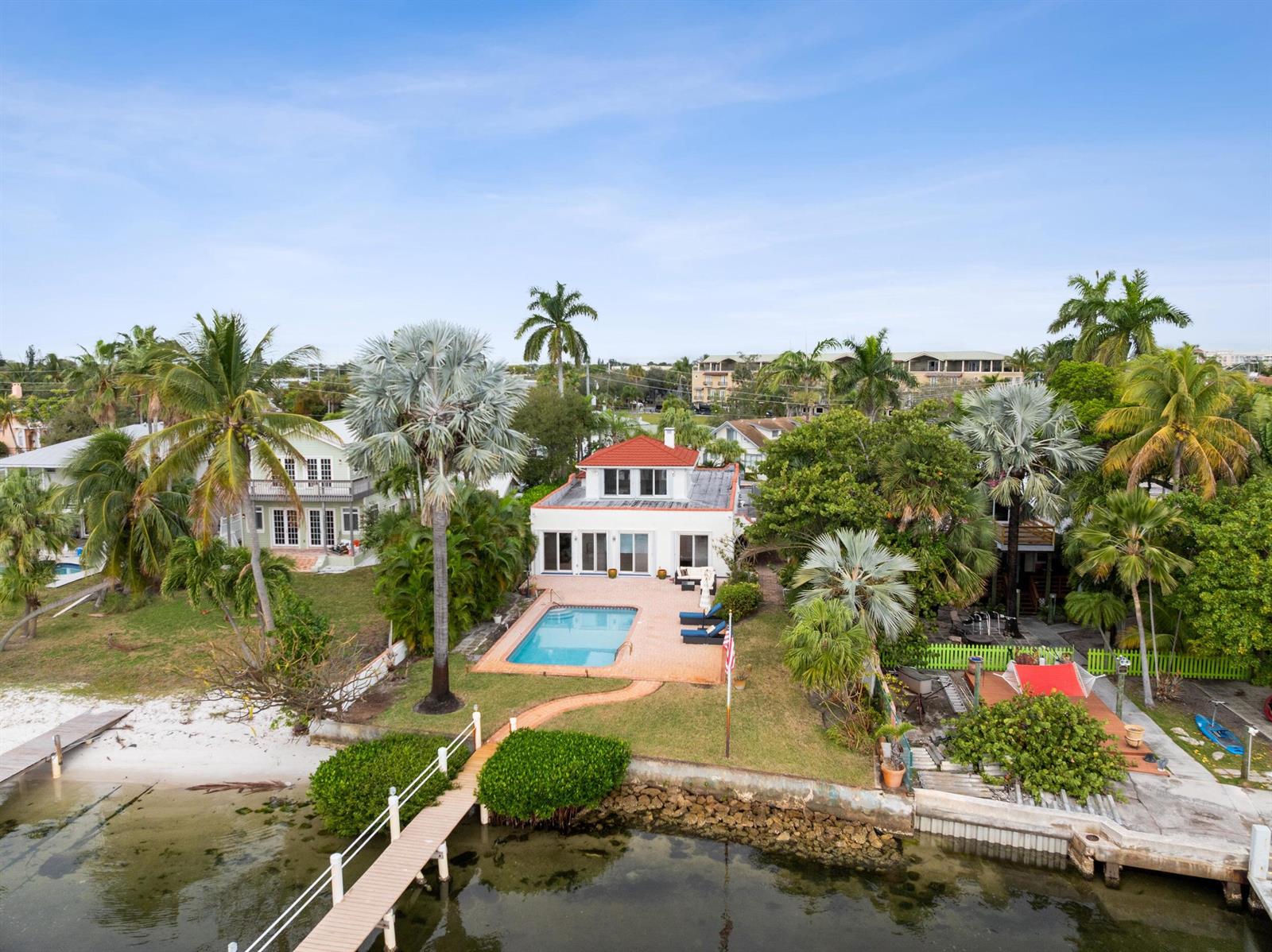 An aerial view of a waterfront house with a swimming pool, dock, and palm trees — 114 S Lake Drive, Lantana FL 33462, LANTANA, FL