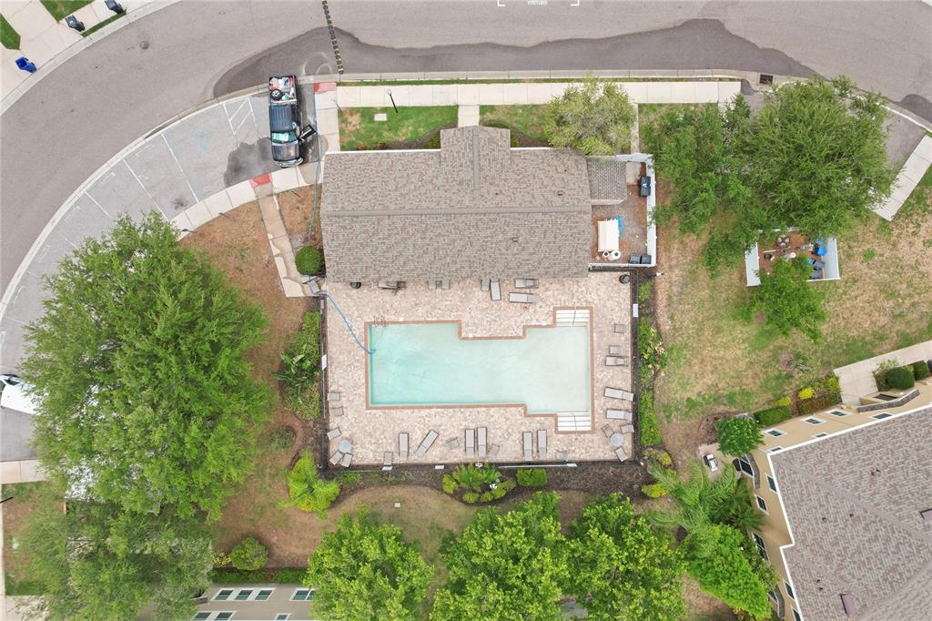 An aerial view shows a house with a large backyard pool and surrounding patio area — 9107 MOONLIT MEADOWS LOOP, RIVERVIEW, FL