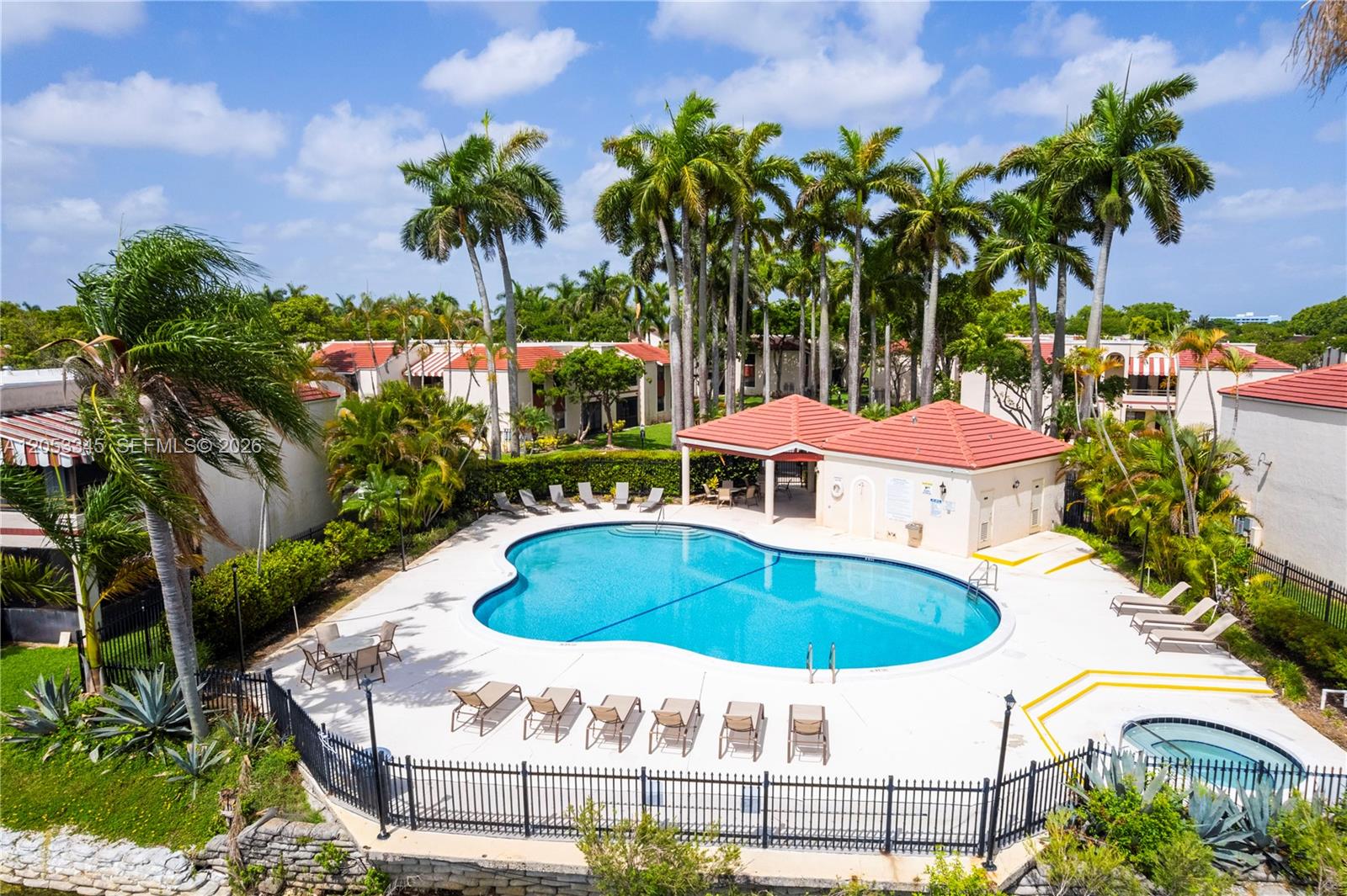 An outdoor swimming pool and hot tub are surrounded by lounge chairs and palm trees — 20260 NE 3rd Ct # 2, Miami FL 33179, MIAMI, FL