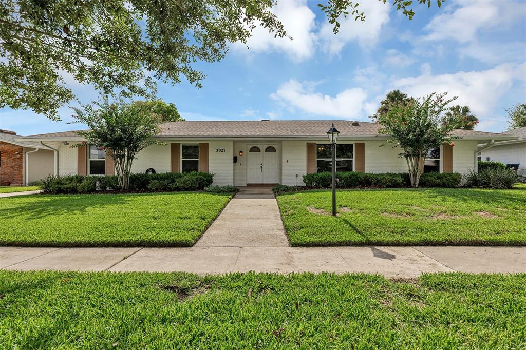 A single-story white brick house features a central entryway, a walkway, and a green lawn — 3021 BRANDYWINE DRIVE, ORLANDO, FL