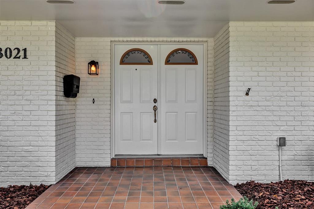A white brick exterior features a double front door with arched glass panels and tile — 3021 BRANDYWINE DRIVE, ORLANDO, FL