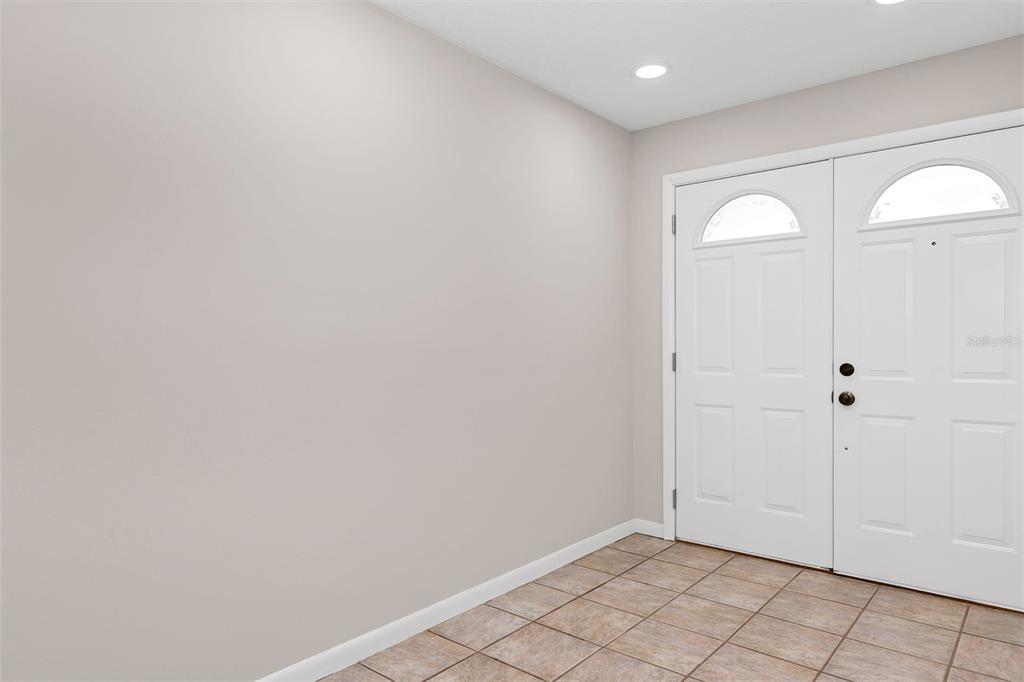 An entryway with light-colored walls, tiled flooring, and a white double front door — 3021 BRANDYWINE DRIVE, ORLANDO, FL