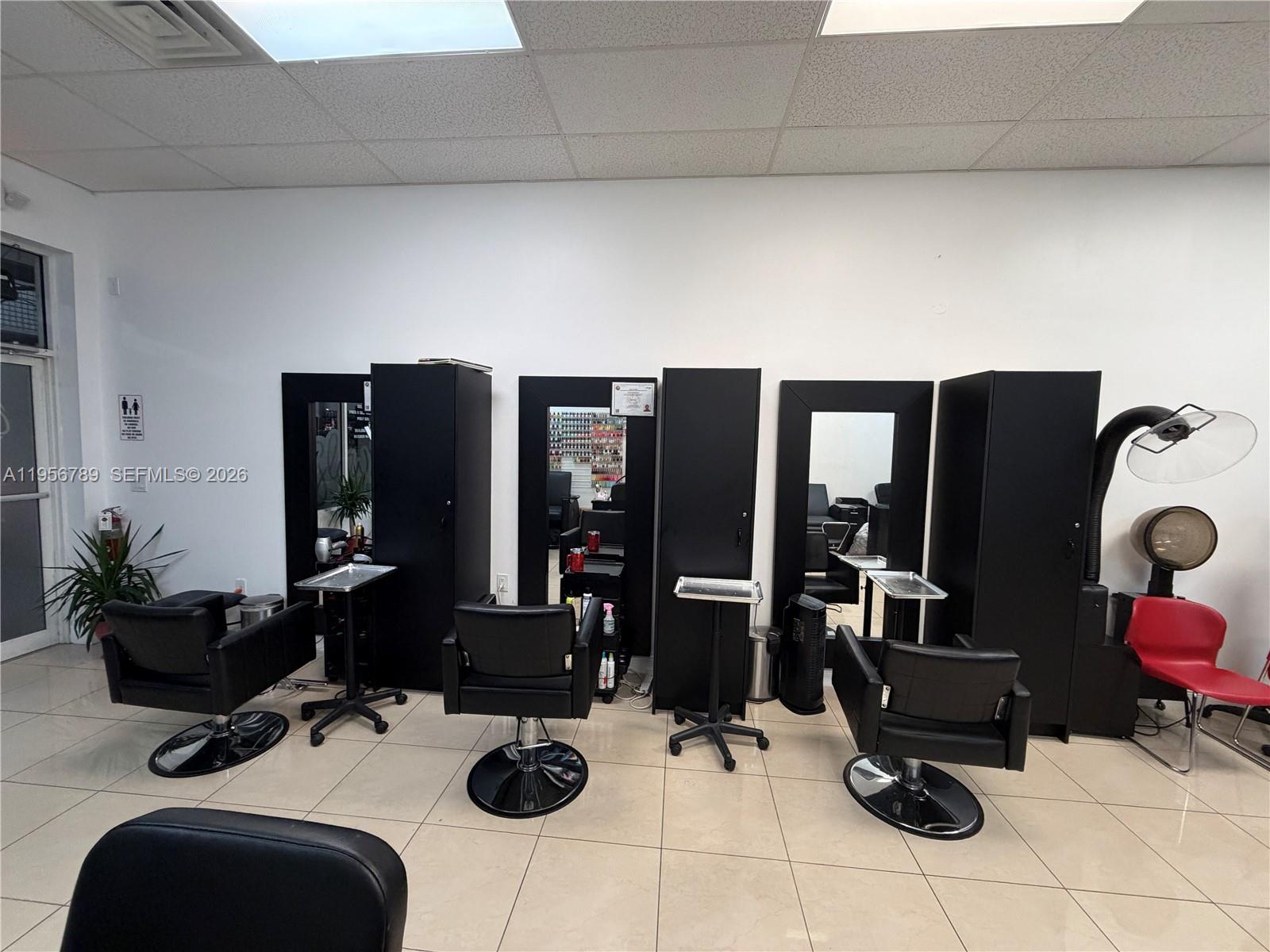 A hair salon features three styling stations with black chairs, mirrors, and storage cabinets — 18505 NW 75th Pl, Hialeah FL 33015, HIALEAH, FL